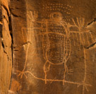 Well here we have an interesting Dinwoody figure.  The square with 'hands' and 'feet' appears to be superimposed over a prior owl like or beetle like figure. This figure has elaborate internal detail including lines, dots and dashes. The body is segmented like a beetle and the tiny head is reminiscent of a dung beetle. The superimposed square character has four fingers and four toes symetricaly with no actual hands, feet, arms or legs indicated. The underlying beetle like glyph has three toes indicated on each 'leg'.  Note that these toes are created by what I call 'minimalist' pecking, that is pecking that is only one peck wide creating a more delicate effect.   The figure has 'wings' indicated by left and right horizontal bars with six lines descending from each. There are dots surrounding the head, Three rows of twelve above and two rows of four to each side. The head appears to have purposeful structure possibly indication large eyes.