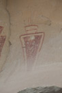 And the right figure under the alcove. This fellow has 2 feathers and some sort of outline coat plus a split headdress of some sort. I think he outranks the fellow on the left. The white between the red feathers appears real. The red tapered field in the center is solid. The gaps are a bullet hole and some sort of strike marks applied postfix.