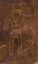 Again a trapazoid Fremont style. This king appears to be wearing a mask. Eyes may be indicated. There is a breast plate and some horizontal decoration on the stomach. The ears have an ear ring treatment. The waist has a decorated belt and again it may match some part of the 'mask'. No weapons are indicated. Arms and legs appear for completeness but are not developed in detail.  
That thing that looks like a ski is not associated with the king as best I can tell.